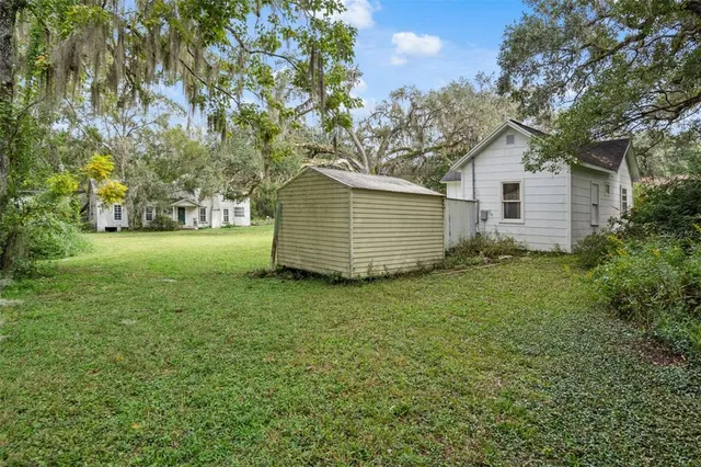 a view of a backyard with large trees
