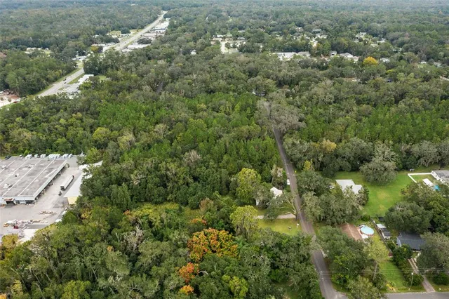 a view of a house with a lush green forest