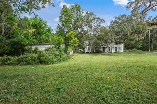a view of a big yard with a house in the background