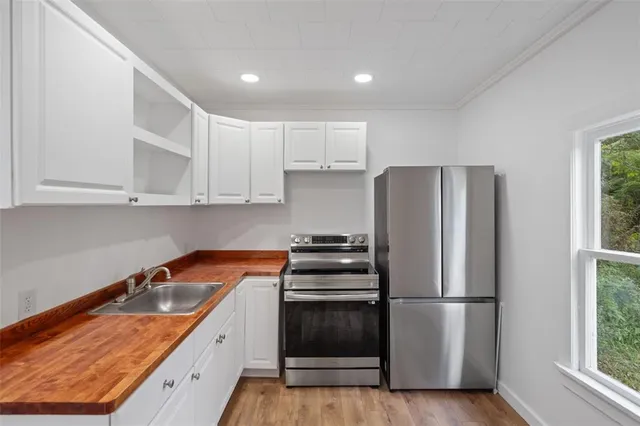 a kitchen with stainless steel appliances granite countertop a refrigerator sink and stove