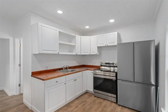 a kitchen with a refrigerator sink and cabinets
