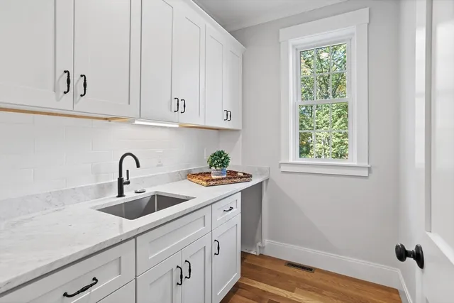 a kitchen with white cabinets and sink