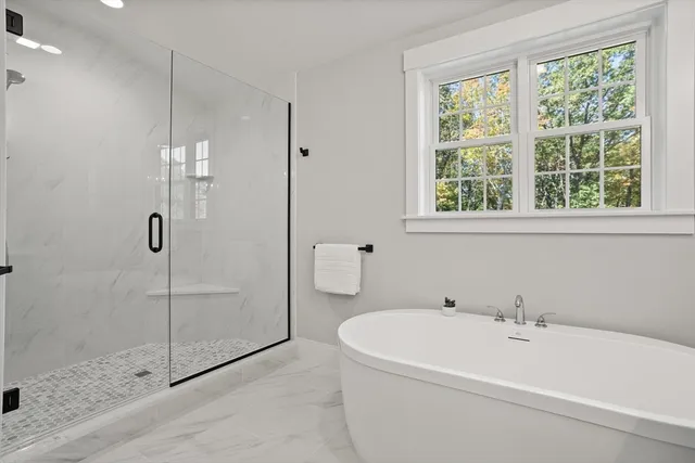 a white bath tub sitting next to a shower