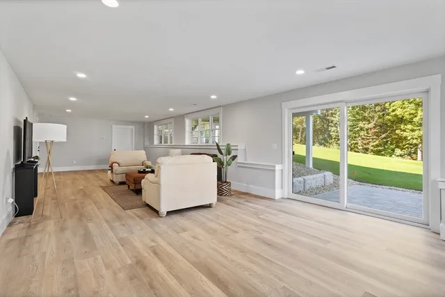 a living room with furniture floor to ceiling window and a flat screen tv