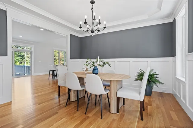 a view of a dining room with furniture wooden floor and chandelier