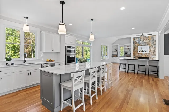 a kitchen with stainless steel appliances granite countertop table chairs stove and sink