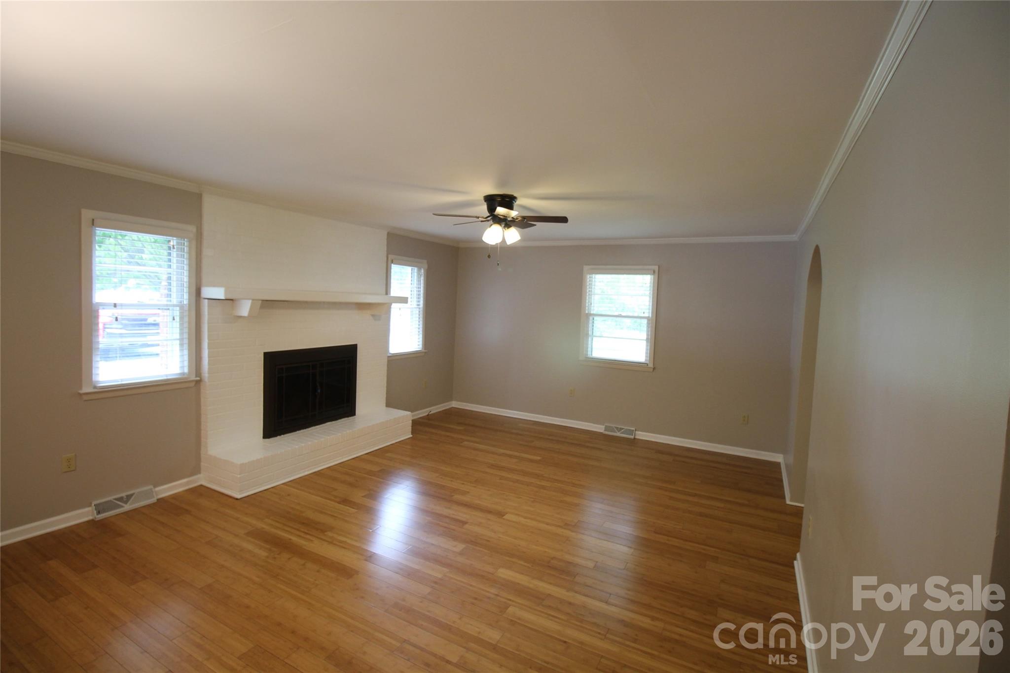 203 Ratchford Farm Road Gastonia, NC 28056 - Photo 9 of 38 a view of an empty room with wooden floor and a fireplace