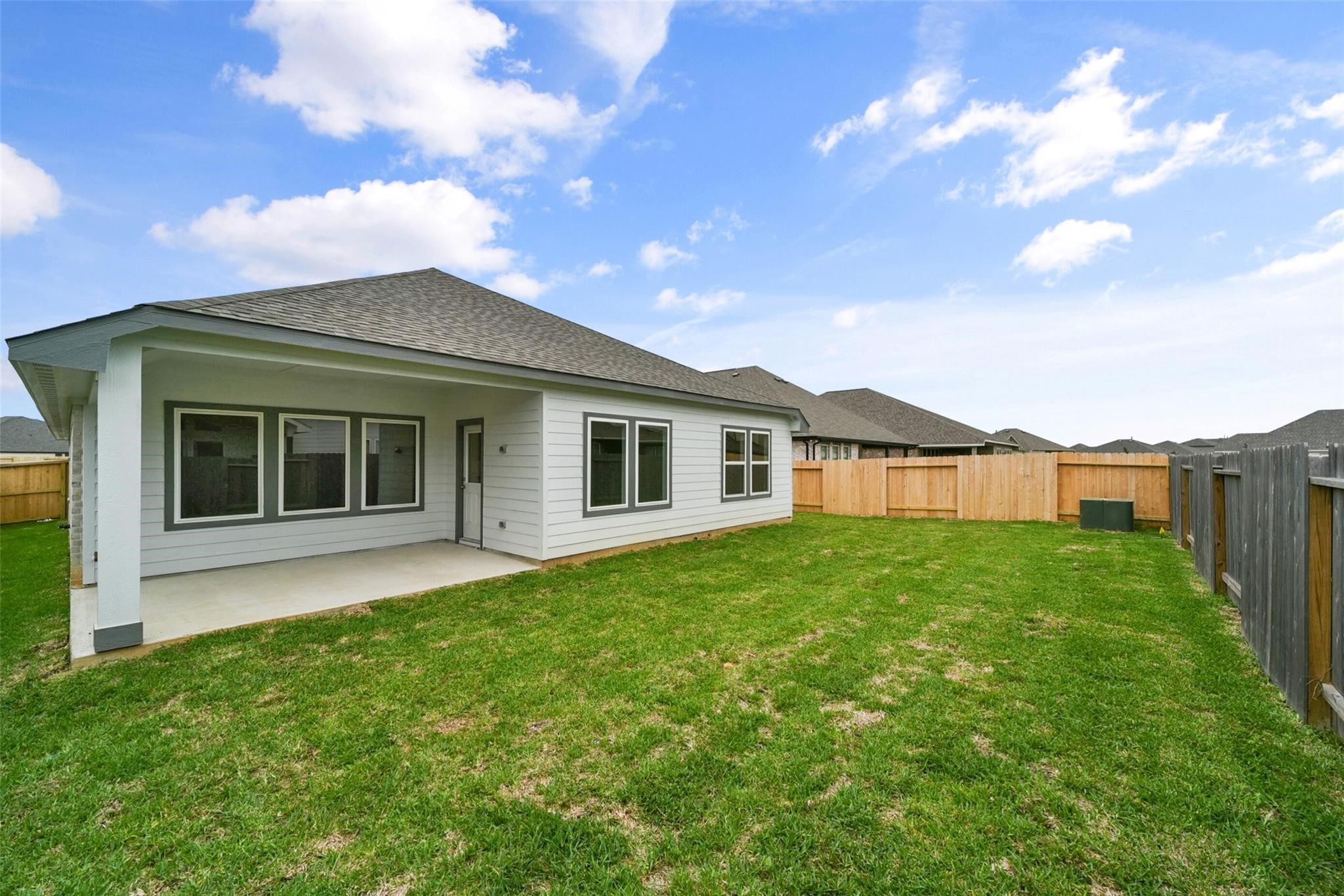 10522 Plumas Run Drive Rosharon, TX 77583 - Photo 28 of 29 Modern single-story home featuring a spacious fenced backyard, covered patio, and large windows that fill the space with natural light.