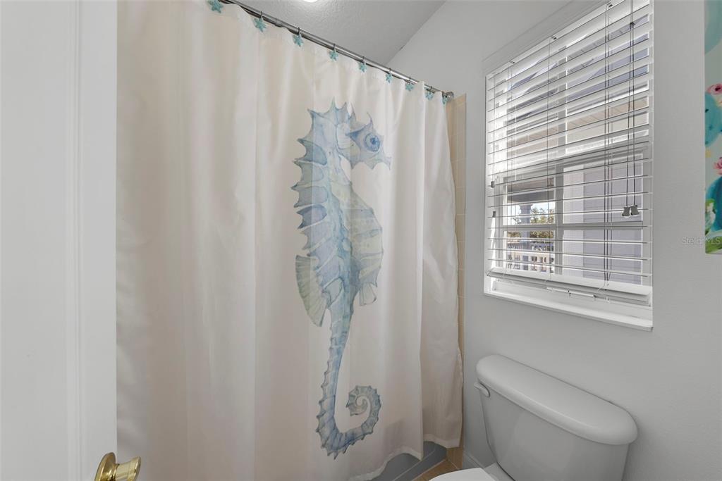 5210 Covesound Way Apollo Beach, FL 33572 - Photo 61 of 82 a bathroom with a shower curtain and a toilet