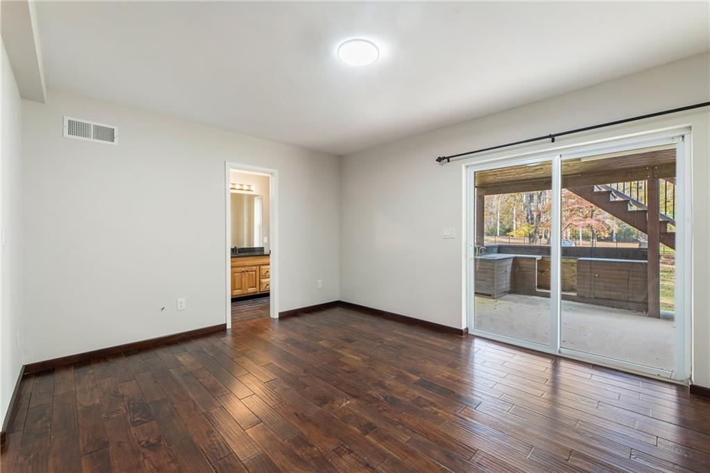 14440 Cogburn Road Alpharetta, GA 30004 - Photo 41 of 62 an empty room with wooden floor and windows