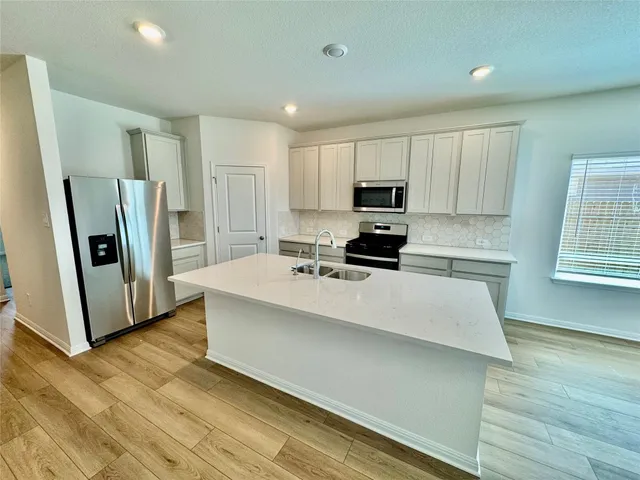 a kitchen with stainless steel appliances a refrigerator sink and microwave
