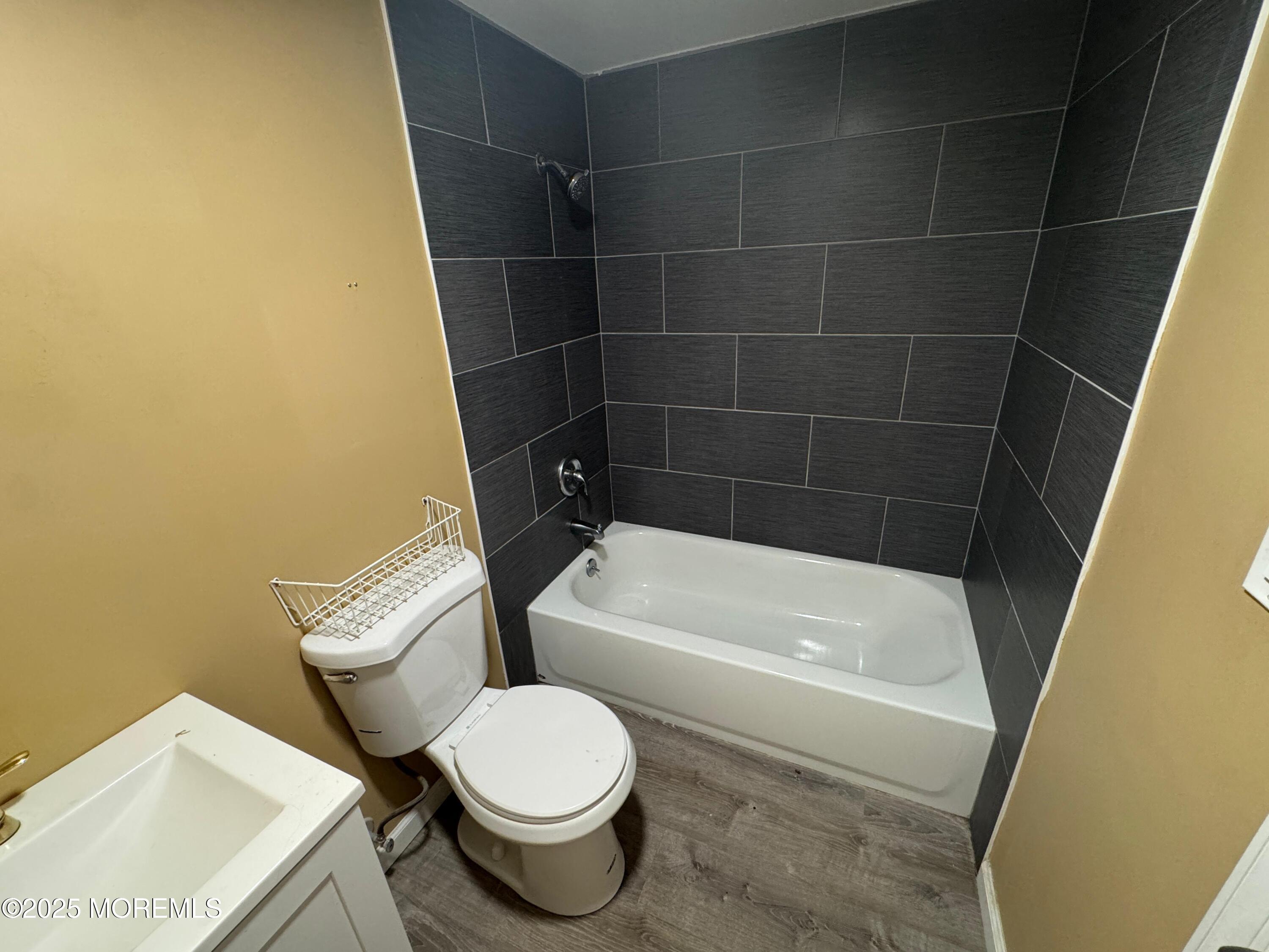 724 Cortlandt Street, Unit 5 Perth Amboy, NJ 08861 - Photo 3 of 10 a white toilet sitting next to a bath tub