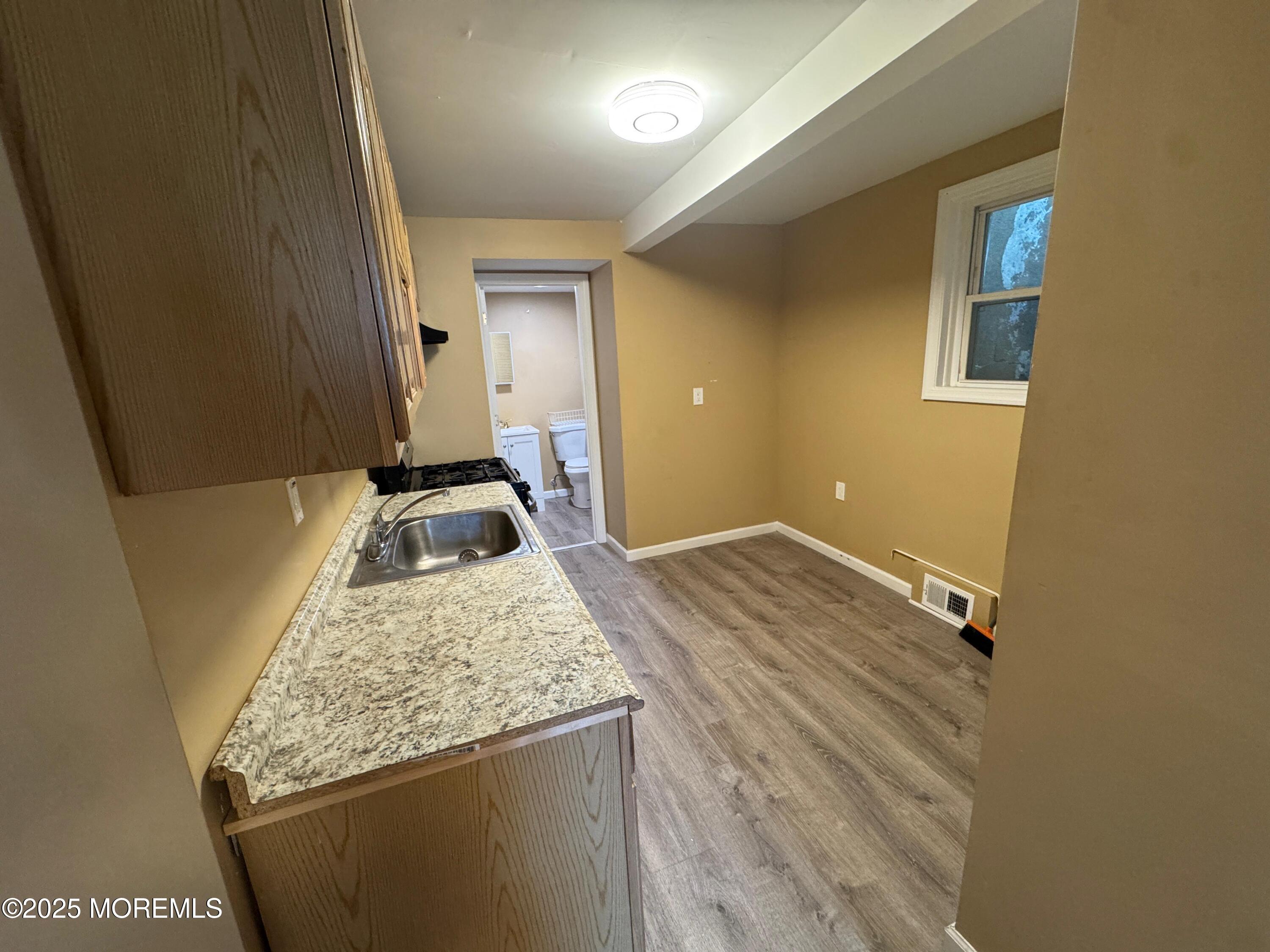 724 Cortlandt Street, Unit 5 Perth Amboy, NJ 08861 - Photo 6 of 10 a bathroom with a granite countertop sink and a mirror
