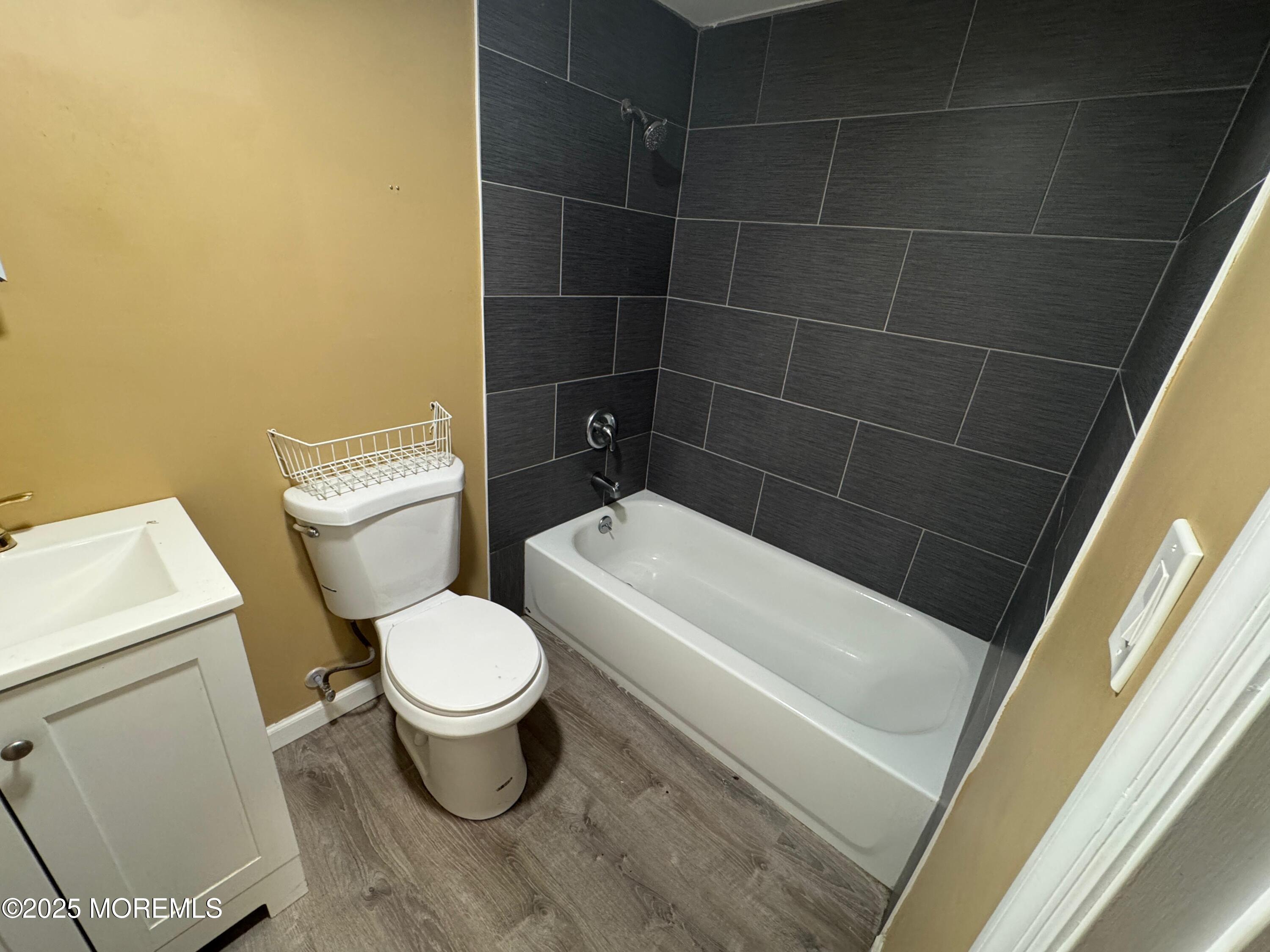 724 Cortlandt Street, Unit 5 Perth Amboy, NJ 08861 - Photo 7 of 10 a white toilet sitting next to a bath tub