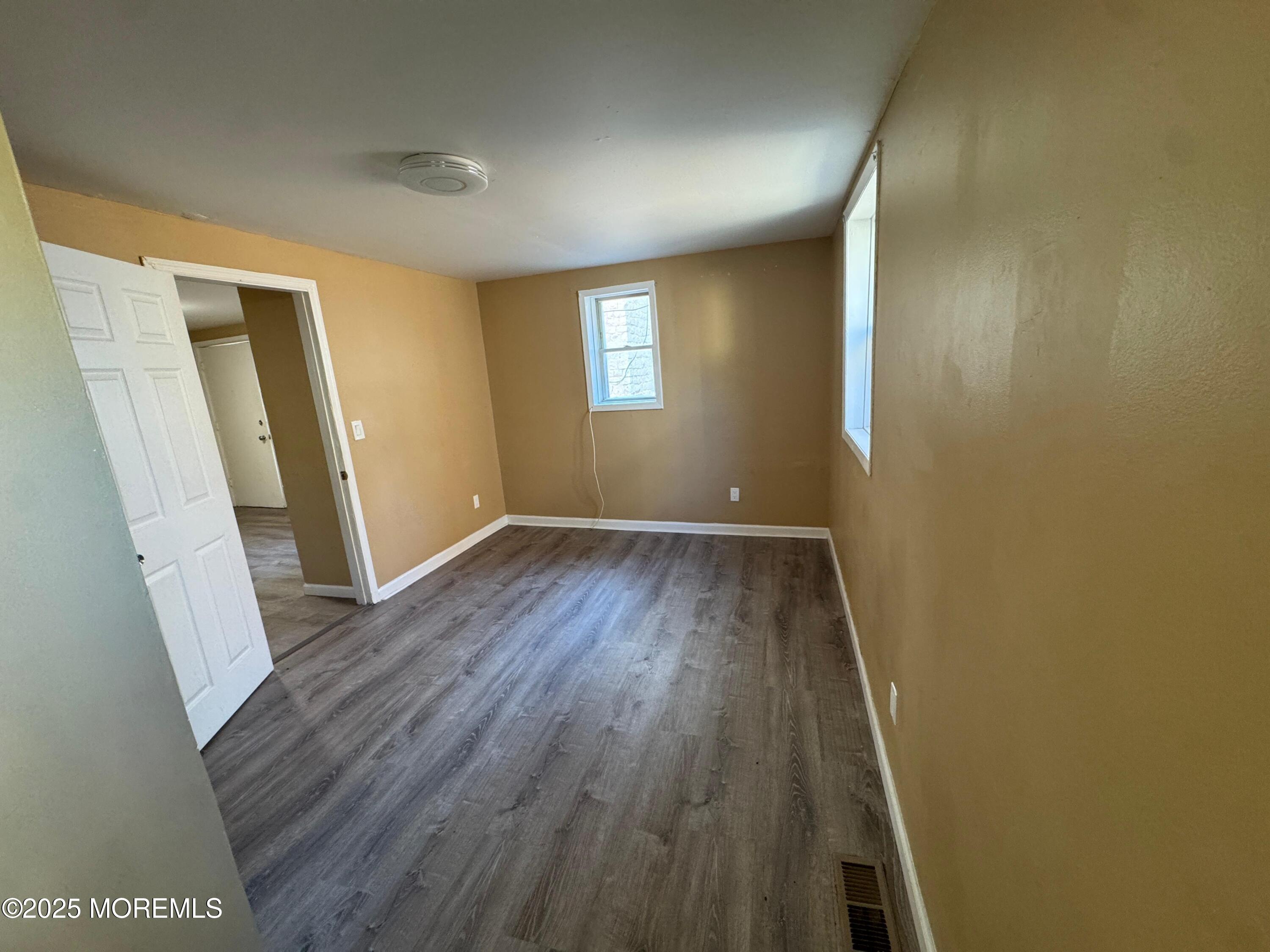 724 Cortlandt Street, Unit 5 Perth Amboy, NJ 08861 - Photo 8 of 10 an empty room with wooden floor and window