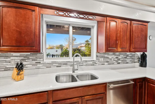 a kitchen with stainless steel appliances granite countertop a sink a stove a refrigerator and cabinets