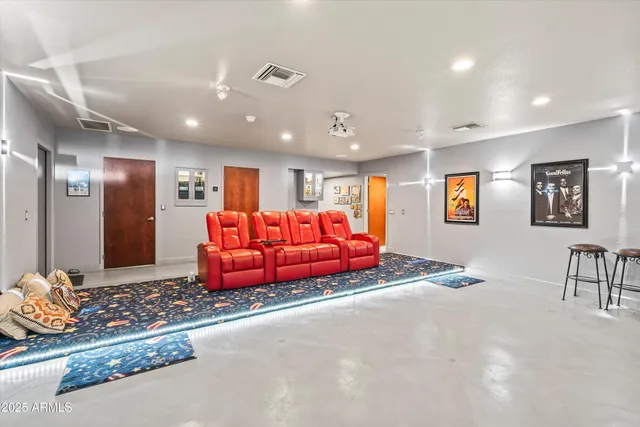 a living room with furniture a projector and kitchen view