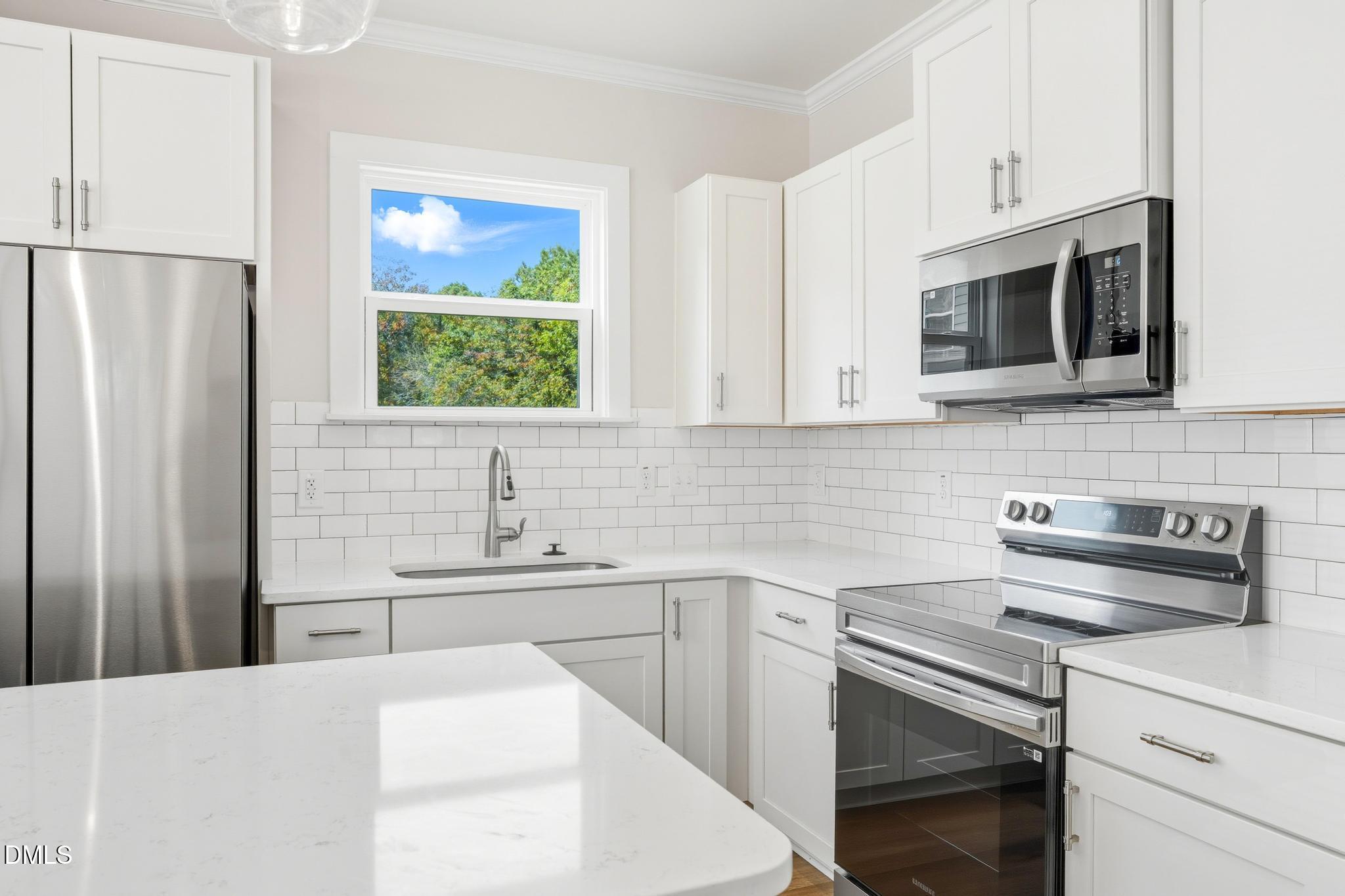 551 Homeland Avenue Durham, NC 27707 - Photo 6 of 32 a kitchen with stainless steel appliances a refrigerator sink and microwave