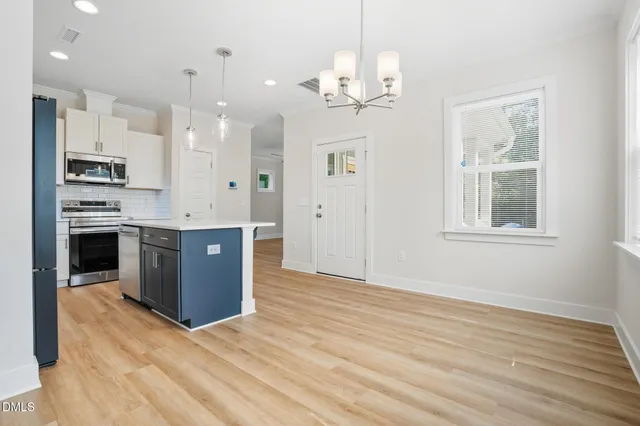 a view of kitchen with granite countertop cabinets stainless steel appliances and a dining table