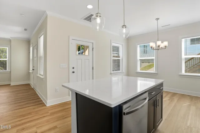 a kitchen with a sink chandelier and wooden floor