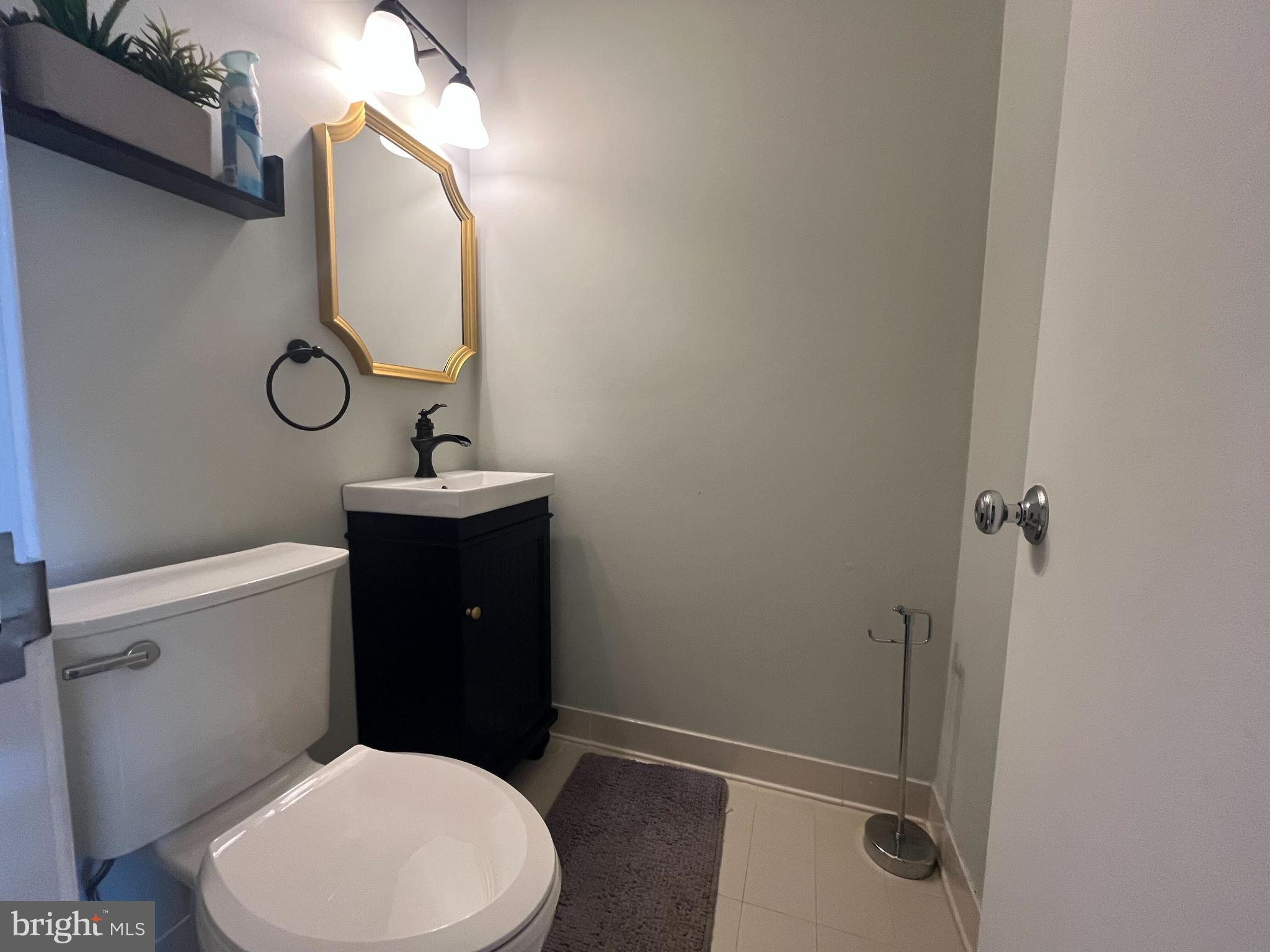 2080 Golf Course Drive Reston, VA 20191 - Photo 8 of 17 a bathroom with a toilet sink vanity and mirror