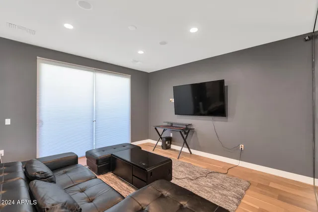 a view of a patio with couches table and chairs under an umbrella