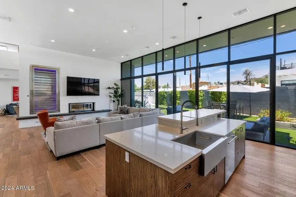 a large kitchen with stainless steel appliances a large counter top a stove a sink dishwasher and a refrigerator