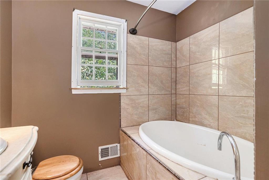 2358 Cannon Hill Road Southwest Lilburn, GA 30047 - Photo 14 of 22 a bathroom with a bathtub and window