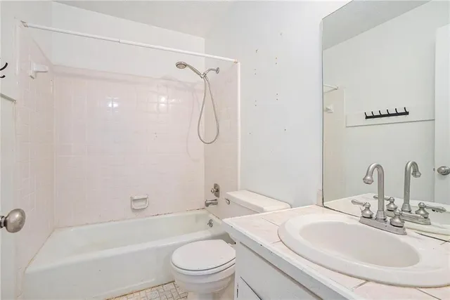 a view of a room with a ceiling fan and wooden floor