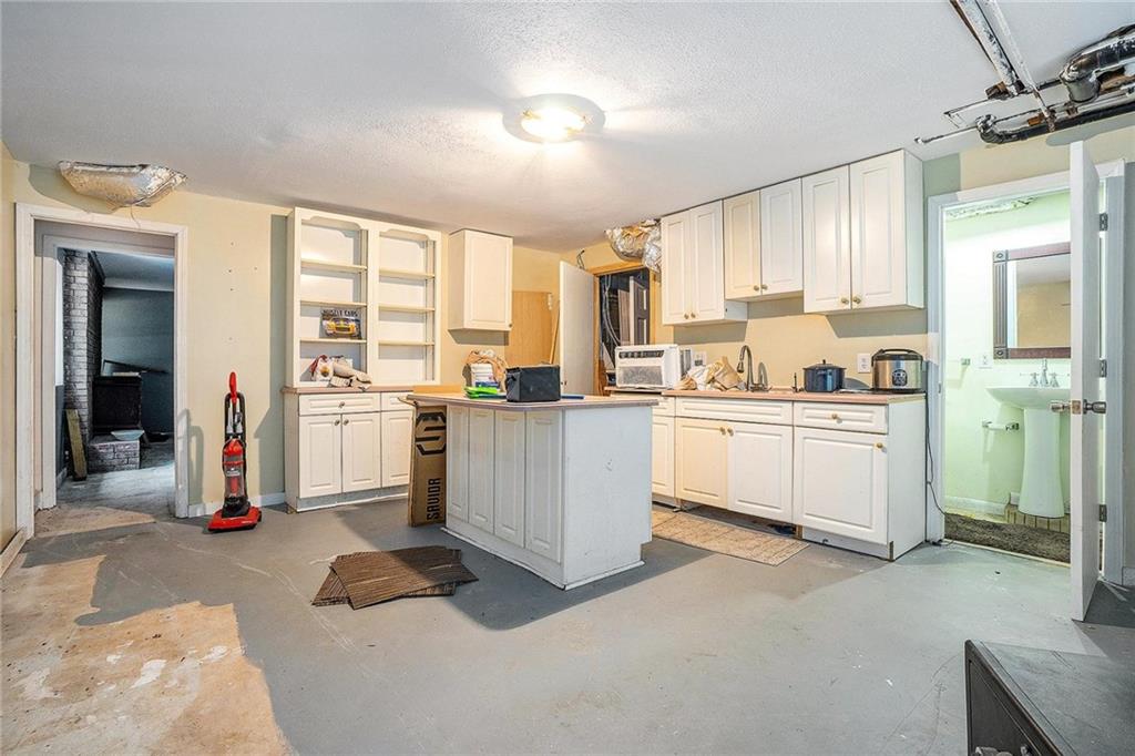 2358 Cannon Hill Road Southwest Lilburn, GA 30047 - Photo 21 of 22 a kitchen that has a lot of white cabinets a sink and appliances