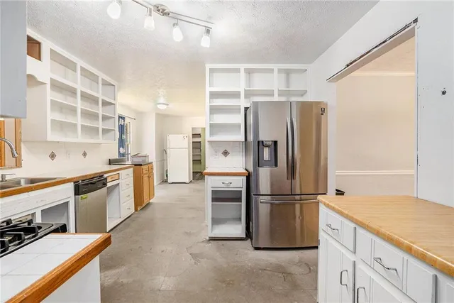 a kitchen with stainless steel appliances granite countertop a refrigerator and a sink