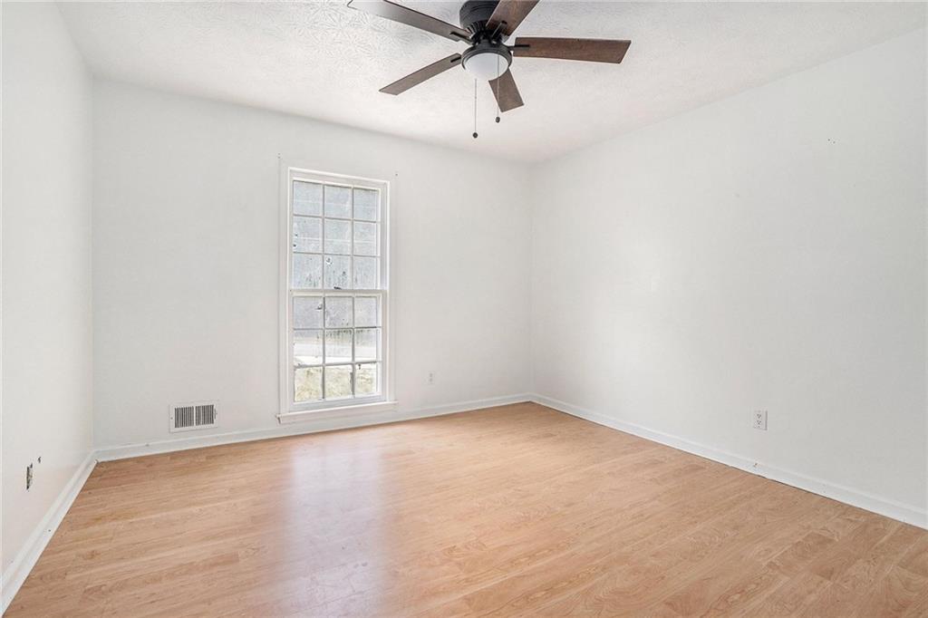 2358 Cannon Hill Road Southwest Lilburn, GA 30047 - Photo 5 of 22 an empty room with a window and a fan