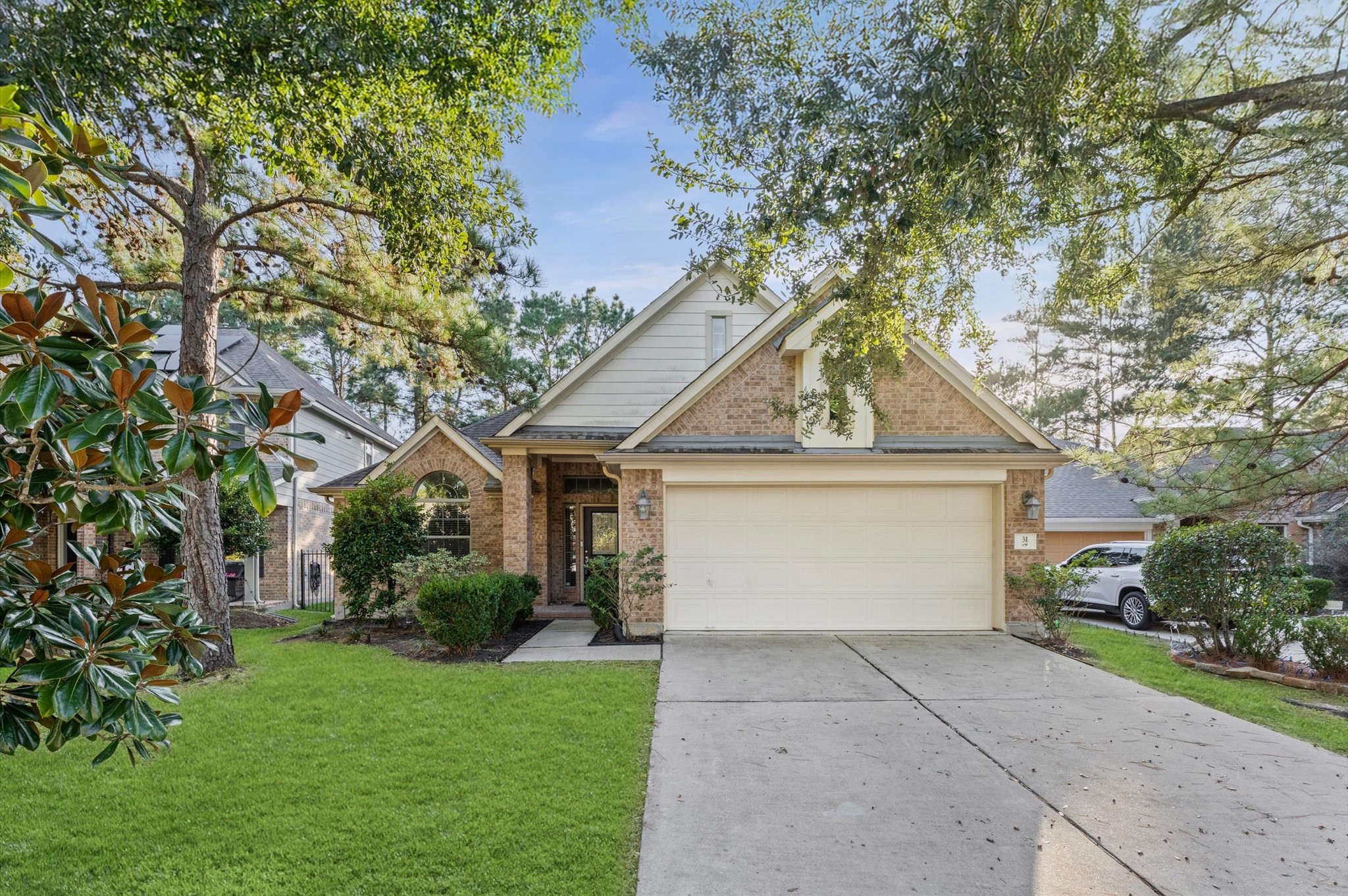 a front view of a house with a garden and trees