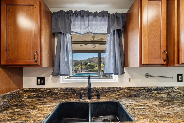 a kitchen with granite countertop a sink and a window
