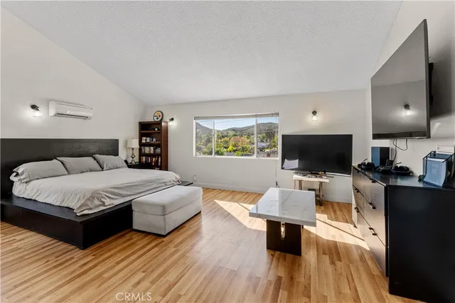 a bedroom with a bed and a flat screen tv