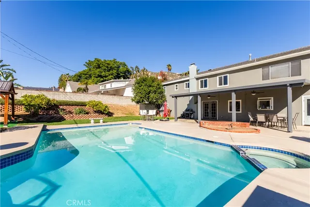 a view of a house with swimming pool and sitting area