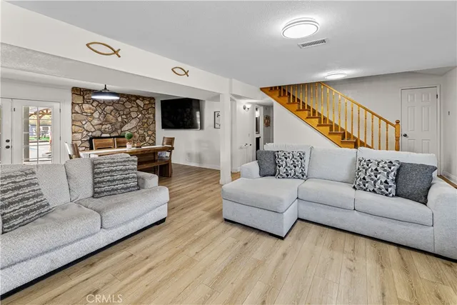 a living room with furniture flat screen tv and a large window