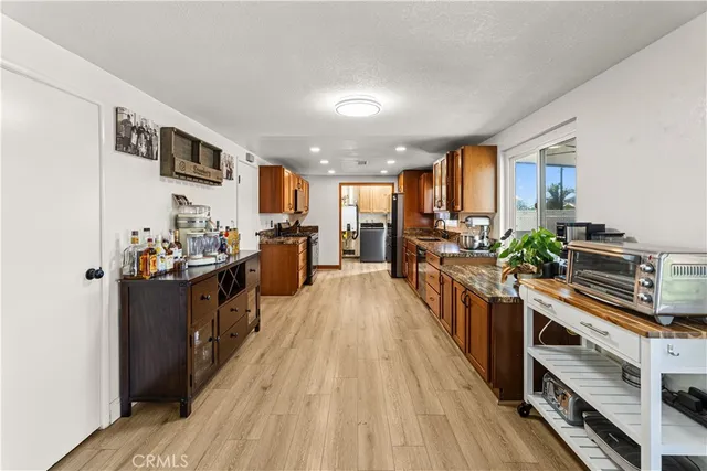 a view of a kitchen with kitchen island wooden floor and stainless steel appliances