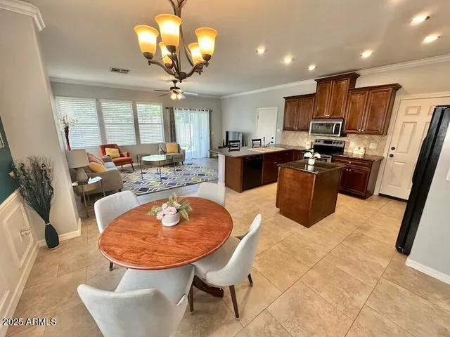 a very nice looking dining room with kitchen island furniture a large window and a fireplace