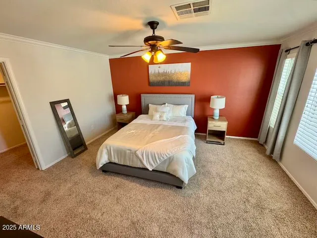 a spacious bedroom with a bed and dresser