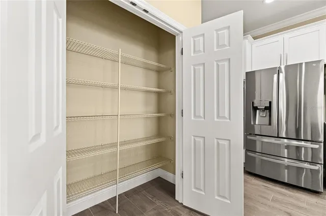 an empty room with wooden floor cabinet and front door