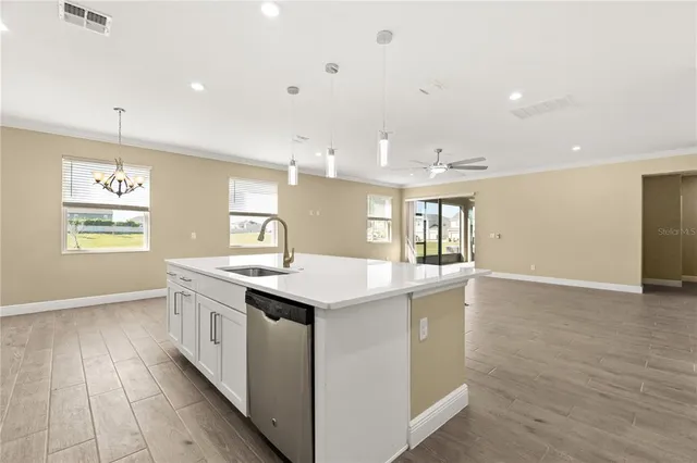 an empty room with windows and ceiling fan