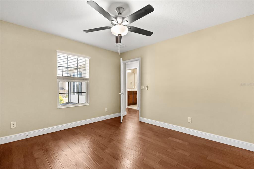 7757 Marsala Street Clermont, FL 34714 - Photo 29 of 75 an empty room with wooden floor chandelier fan and windows