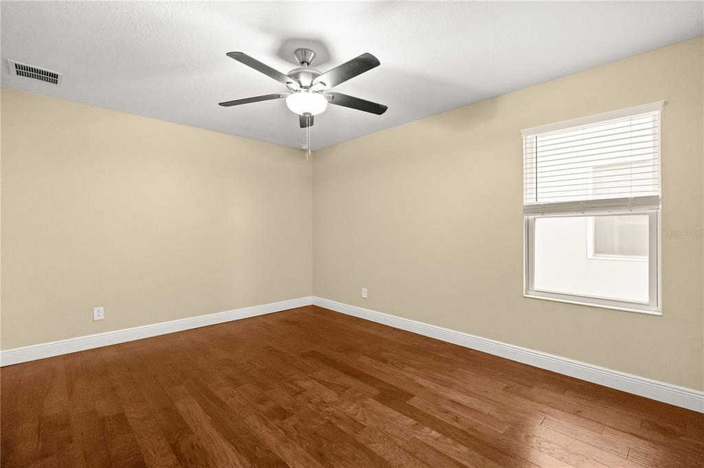 7757 Marsala Street Clermont, FL 34714 - Photo 31 of 75 an empty room with wooden floor fan and windows