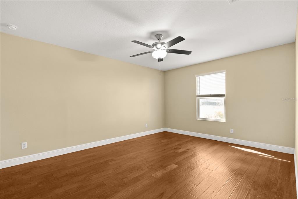 7757 Marsala Street Clermont, FL 34714 - Photo 34 of 75 a view of empty room with wooden floor and fan