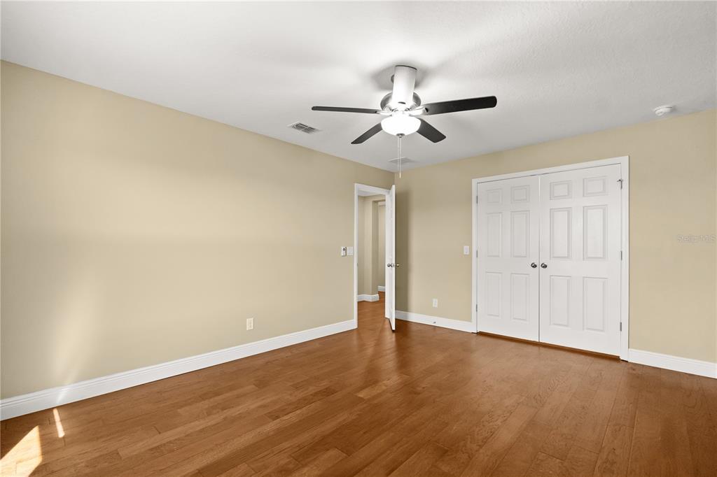 7757 Marsala Street Clermont, FL 34714 - Photo 35 of 75 an empty room with wooden floor and ceiling fan