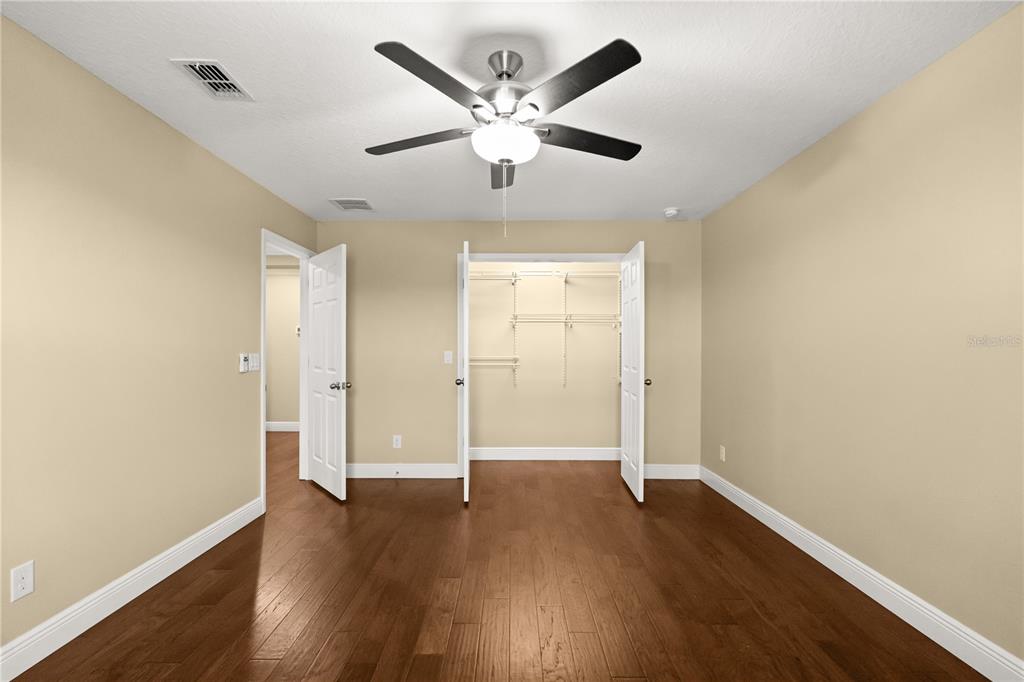 7757 Marsala Street Clermont, FL 34714 - Photo 36 of 75 an empty room with wooden floor and ceiling fan