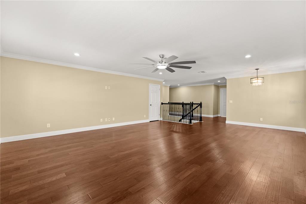 7757 Marsala Street Clermont, FL 34714 - Photo 39 of 75 a view of empty room with wooden floor and fireplace