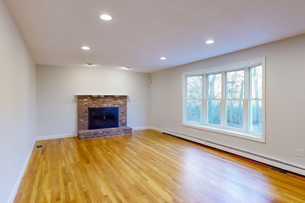 7 Delaney Drive Walpole, MA 02081 - Photo 10 of 35 a view of an empty room with a fireplace and a window