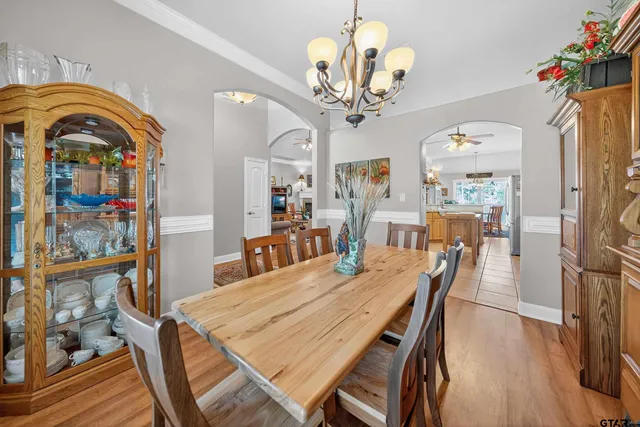 a view of a dining room with furniture a chandelier and wooden floor